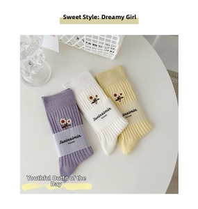 Dettaglio di calze a costine con ricamo a margherita nei colori viola, bianco e giallo