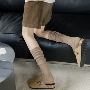 Retro khaki mules with cork midsole and matching ribbed knit crew socks in home setting