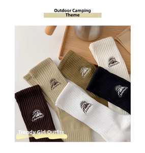 Close-up of five colorful cotton socks with mountain embroidery and camping text