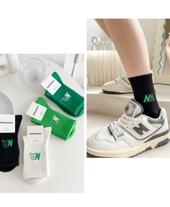 Détail de chaussettes en coton côtelé avec broderie NA verte et emballage d'origine