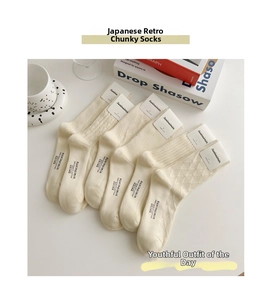 Dettaglio di cinque paia di calze di cotone beige con varie trame a maglia e confezione