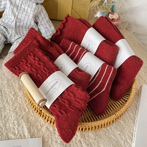 Set of deep red knit socks with cable patterns and frill cuffs in a festive gift tray