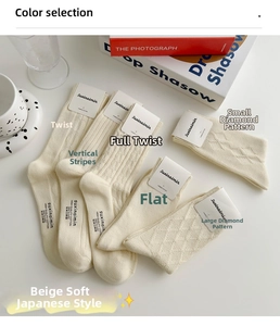 Dettaglio di calze di cotone beige che mostrano varie trame di maglia e punti diversi