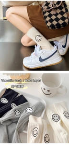 Detail view of cotton mid-calf socks featuring cute embroidered smile faces in various colors
