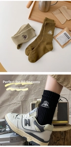 Detail of embroidered camping mountain logo on vintage style cotton ribbed mid-tube socks