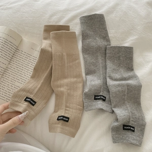 Ribbed knit slouch socks in coffee and grey displayed with aesthetic book props
