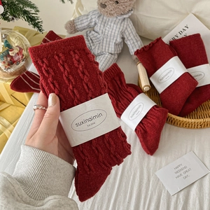 Winter red cable knit wool socks for New Year gift set shown in a cozy home setting