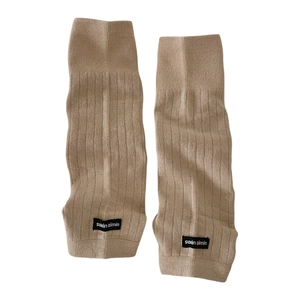 Ribbed knit leg warmers in beige featuring minimalist black logo tags on white background
