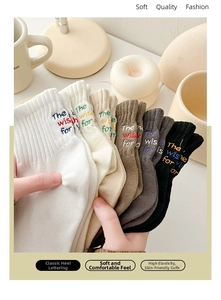 Detail of six-color mid-calf socks set with embroidered heel text in warm neutral tones