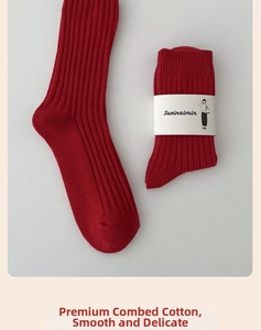 Close-up of red combed cotton mid-calf socks with classic ribbed knit and paper packaging