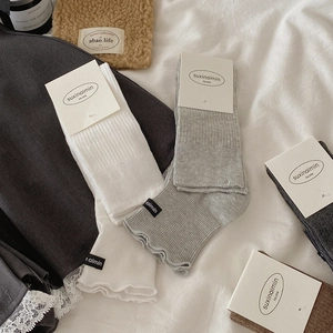 Ribbed crew socks with lettuce edges and letter labels in various neutral colors