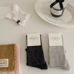 Three pairs of striped mid-calf socks in black, grey, and white with cotton texture