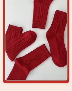 Close-up of red cotton socks showing detailed cable knit and diamond texture pattern