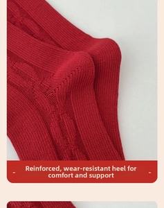 Detail of reinforced heel and thick cable knit texture on festive red cotton socks