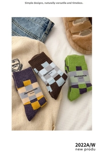 Three pairs of thick checkerboard pattern wool socks in vintage colors on white fabric