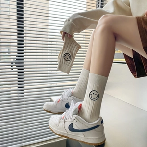 Beige ribbed crew socks with cute black embroidered smiley face on a model