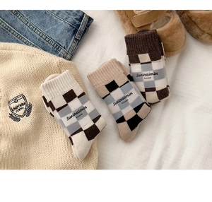 Detailed knit texture of thick checkerboard wool socks in a cozy winter style layout
