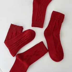 Classic red knitted crew socks with argyle and cable patterns for New Year wear