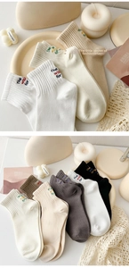 Detail of soft cotton crew socks with embroidered letters and elastic ribbed cuffs