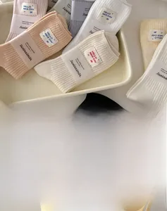 Detail of ribbed knit cotton socks in pastel tones with embroidered cloth labels