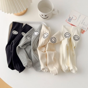 Ribbed cotton mid-calf socks with embroidered smiley face patches in four neutral colors