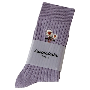 Calze in cotone a righe viola con ricamo a margherita su sfondo bianco neutro