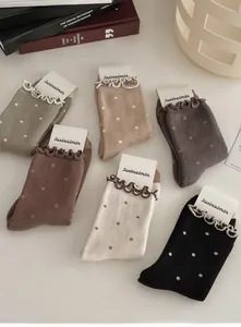 Detail of warm winter crew socks with wavy frill cuffs and classic polka dot patterns