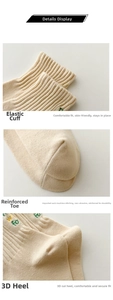 Detail of cream cotton socks showing ribbed cuffs, green embroidery, and reinforced toe