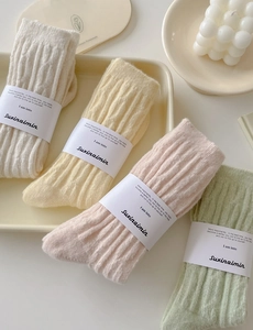 Close-up of four pairs of ribbed winter socks in soft pastel colors in a tray