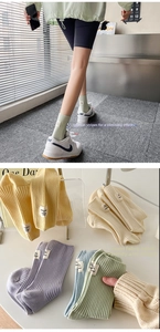 Detailed view of ribbed knit mid-tube socks with minimalist sewn tags in pastel colors