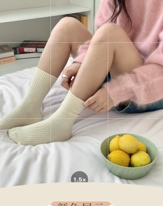 Close-up of cream ribbed cotton mid-calf socks shown in a cozy home lifestyle setting