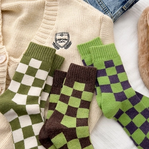 Thick checkered wool socks for women in green patterns shown on a cozy outfit layout