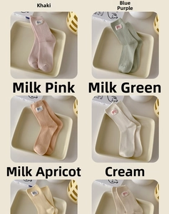 Detailed view of ribbed cotton crew socks with hello nice day cloth label in pastel colors