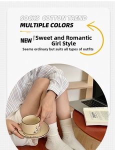 Detailed knit texture of white cotton mid-calf socks shown in a cozy home lifestyle setting