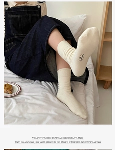 Close-up of off-white velvet mid-calf socks with ribbed texture and reinforced weave