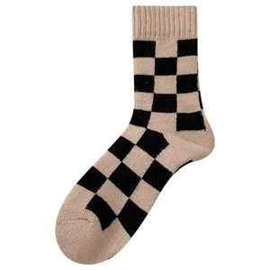 Thick wool socks featuring a black and beige checkerboard pattern in a mid-calf crew length