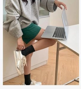 Close-up of metallic silver retro sneakers with grey mid-calf socks and green skirt