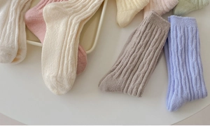 Detail of cable knit wool socks in pastel colors with cozy ribbed texture and thick fabric