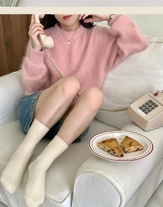Close-up of pink mohair texture sweater and off-white ribbed mid-calf socks for autumn wear