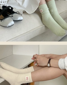Close-up of ribbed cotton crew socks with Hello Nice Day woven label in green and cream