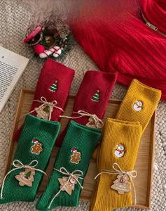 Detailed view of Christmas mid-calf socks with embroidery and festive kraft gift tags
