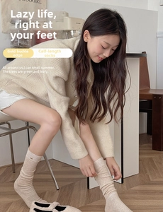 Gros plan de chaussettes en maille beige avec de petits boutons dorés sur le côté