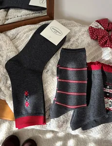 Close-up of grey knit crew socks featuring Fair Isle patterns and festive snowflake designs