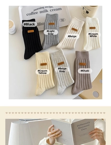 Detailed view of ribbed mid-calf socks with vintage leather patches in seven neutral colors