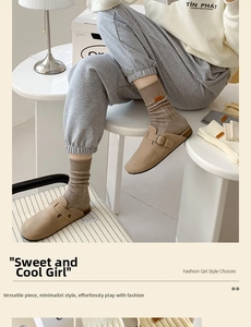 Detail of oatmeal ribbed crew socks with leather tag paired with suede buckle clogs