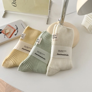 Three-pack cotton ribbed crew socks in sage green, cream yellow, and ivory white