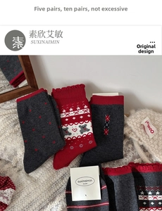 Detailed close-up of grey and red knitted socks with Nordic patterns on lace background