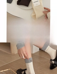 Detail of combed cotton crew socks with ribbed cuffs and decorative vintage buttons