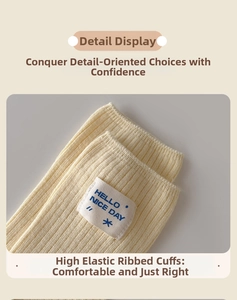 Detail of cream ribbed knit sock with 'HELLO NICE DAY' fabric label and elastic cuff