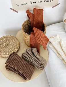 Détails de jambières en tricot chaud aux tons terreux avec bords ondulés et mailles épaisses
